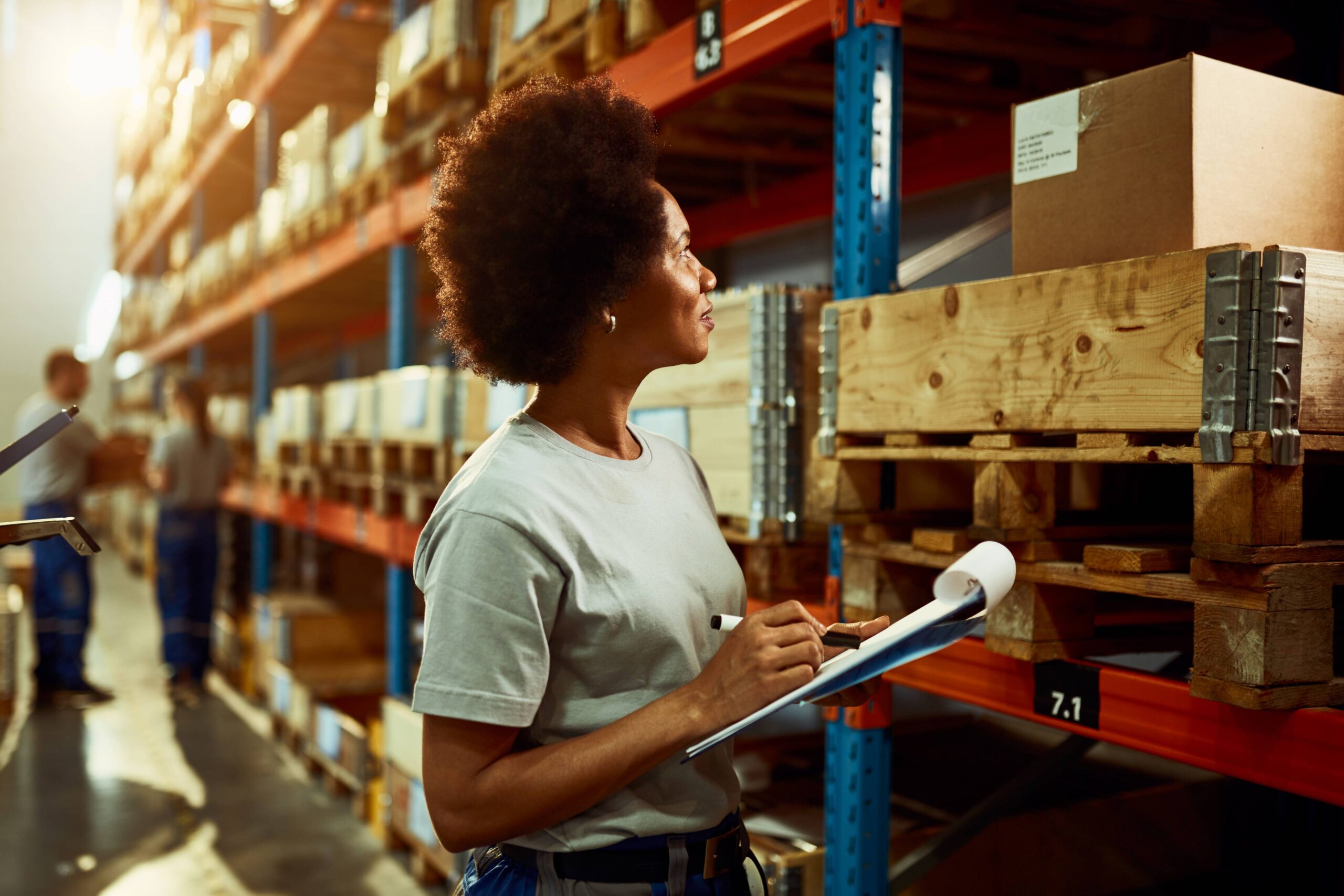 african american worker writing inventory list while checking stock storage room 1